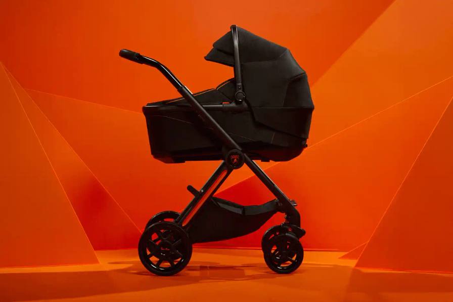 Black and orange Lamborghini x Silver Cross Reef AL Arancio baby stroller with full suspension wheels, leather accents, and automotive-inspired handlebars shown against neutral background.