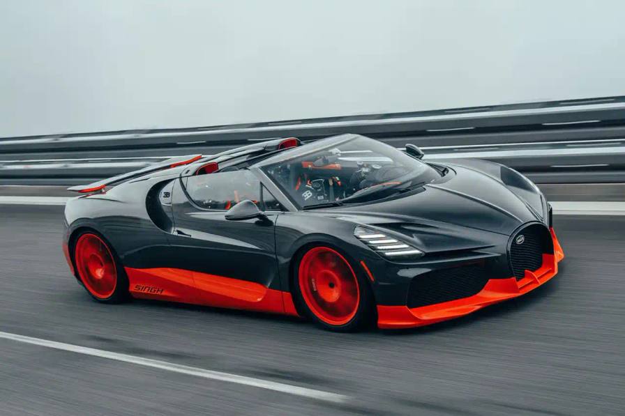 Bugatti, the renowned manufacturer of high-performance luxury automobiles, has once again pushed the boundaries of automotive engineering with the remarkable achievements of its W16 Mistral model. On November 9th, the W16 Mistral set a new world record for the fastest open-top car, reaching a staggering speed of 453.91 km/h (281 mph) at the ATP Automotive Testing Papenburg track in Germany. The record-breaking run was piloted by Andy Wallace, Bugatti's official test driver and a renowned Le Mans winner, showcasing the exceptional capabilities of the W16 Mistral. This remarkable feat builds upon Bugatti's legacy of record-setting performance, including the Veyron 16.4 Grand Sport Vitesse's 408.84 km/h (253 mph) record achieved in 2013 and the Chiron Super Sport 300+'s 490.48 km/h (304 mph) closed-cockpit record set in 2019. The W16 Mistral, a bespoke $14.8 million USD model, features a striking black carbon body with "Jet Orange" accents, paying homage to Bugatti's previous record-setting vehicles. The event was attended by Mate Rimac, CEO of Bugatti Rimac, as well as Bugatti's senior team and the vehicle's owner, a collector from Punjab, India. Highlighting the W16 Mistral's prowess, the owner had the opportunity to experience the car's remarkable speed firsthand, joining Wallace for a high-speed run. This latest addition to The Singh Collection joins an exclusive lineup of Bugatti's record-breaking automobiles.