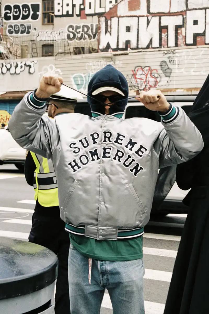 image of the Spring 2025 collaboration between Supreme and Homerun, a brand based in both New York City and Tokyo. The collection features baseball-inspired apparel including varsity jackets in silver and black, baseball jerseys in teal, navy, and pinstriped designs, plus hooded sweatshirts, t-shirts, and New Era caps. All items display co-branding with Homerun's cartoon graphics and "Non Stop" motto. The collection launches May 15 globally and May 17 in Asia through Supreme's website and stores.