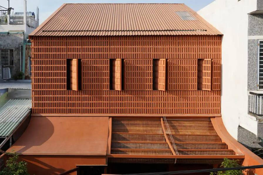 Live Out Studio, A residential house in Da Nang, Vietnam features perforated terracotta brick walls and internal courtyards to provide ventilation and natural light in a narrow urban lot.