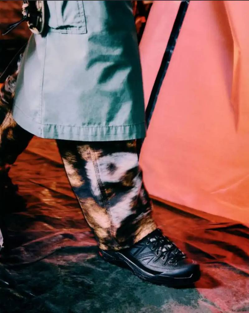 Carhartt WIP and Salomon collaborate on the X-ALP sneaker, featuring black leather upper with suede layers and camouflage details, releasing December 18.