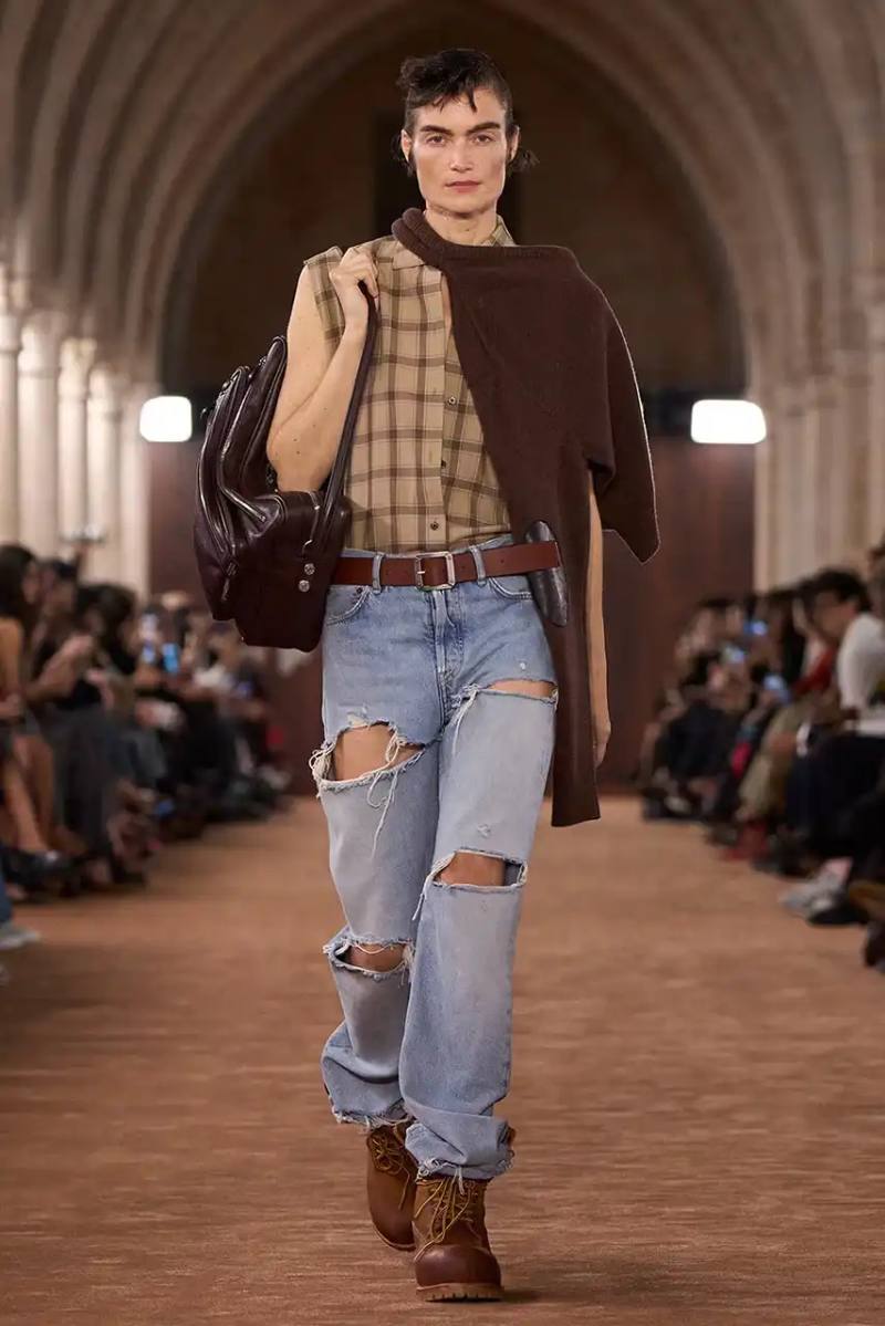 Acne Studios presented a collaborative 6-Inch boot with Timberland during its Spring/Summer 2026 Paris Fashion Week runway show. The boot features washed brown tones and minimal design changes.