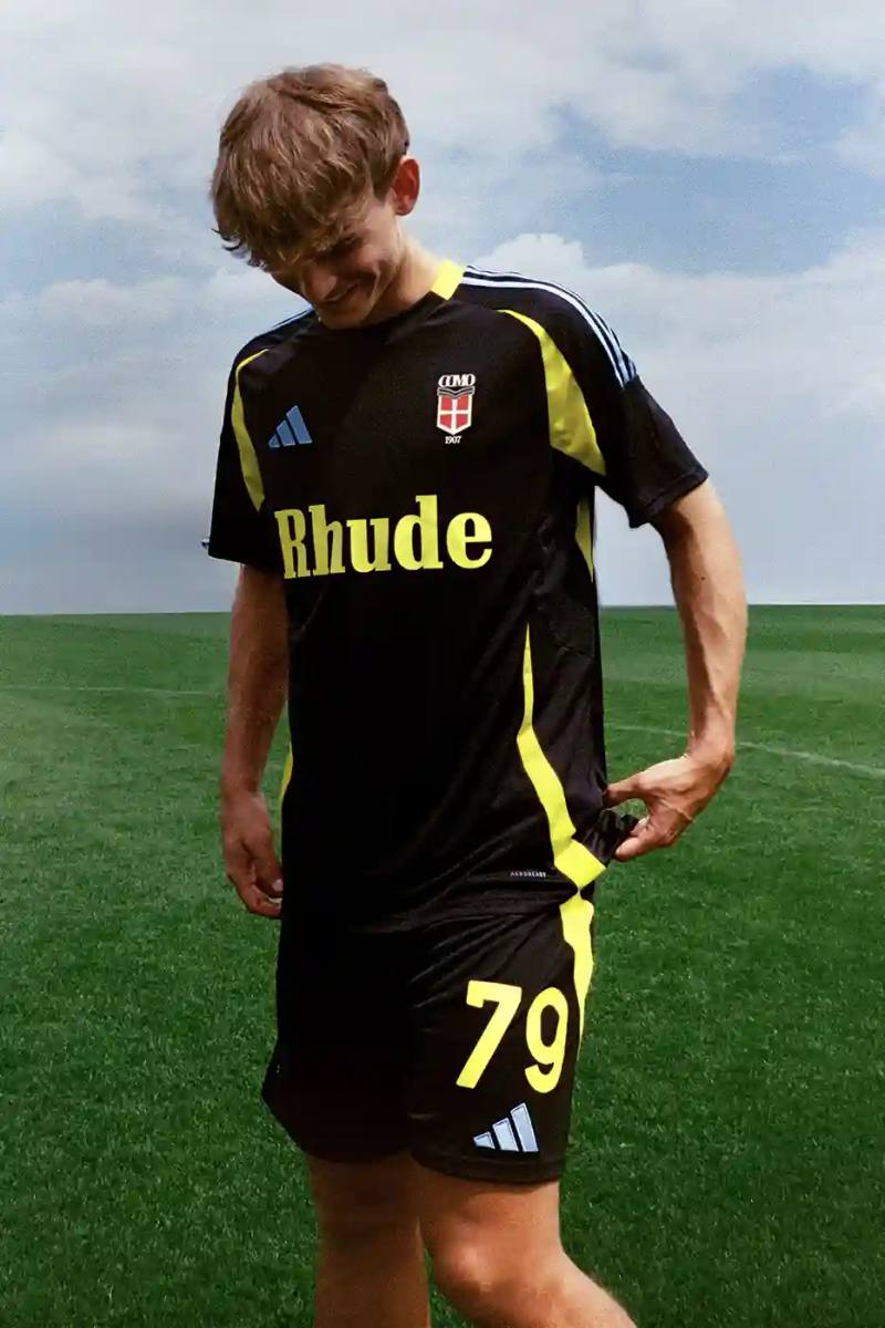 image about Italian football club Como 1907's new jersey collaboration with fashion brand Rhude and Adidas. The limited-edition black and gold kit celebrates the team's return to Serie A after 21 years and combines Italian lakeside heritage with Los Angeles street fashion aesthetics. Priced at €275, the jersey features technical fabric and special branding elements.