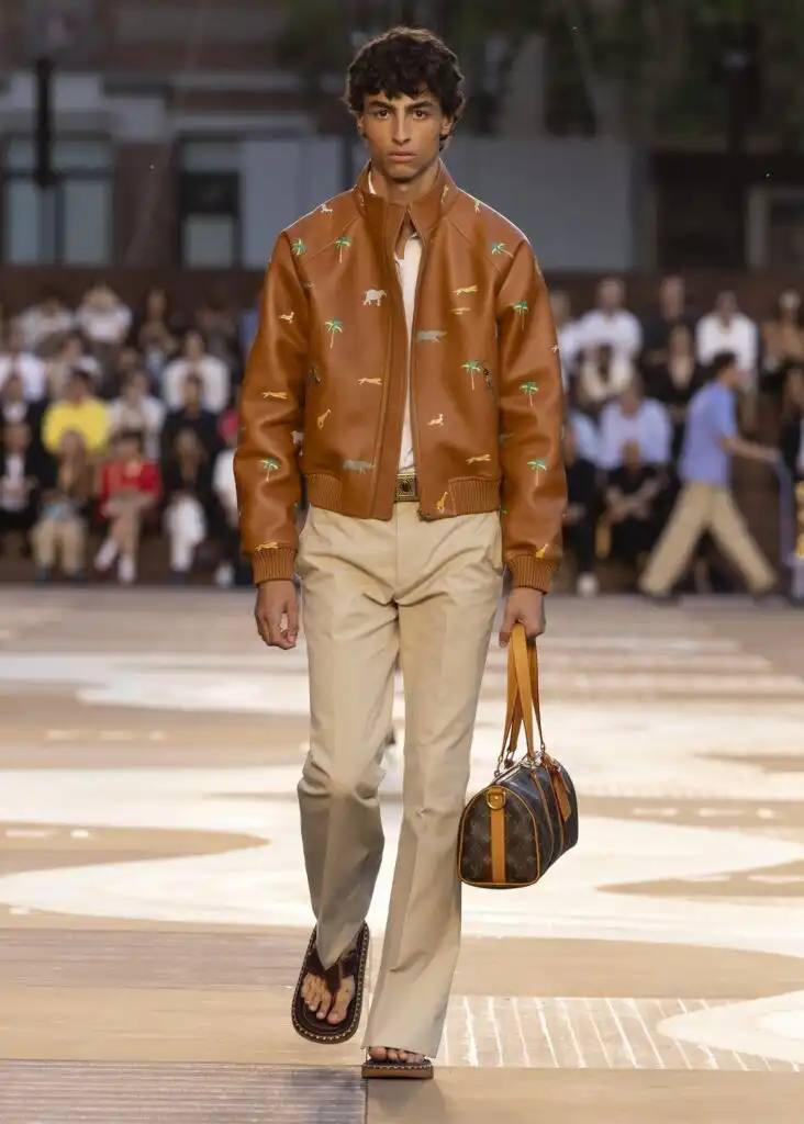 LOUIS VUITTON SS26 MEN'S COLLECTION DRAWS FROM INDIA image about Louis Vuitton's Spring/Summer 2026 men's collection presented by Creative Director Pharrell Williams. The collection draws inspiration from contemporary Indian style, features warm sun-bleached colors, and incorporates archival leather goods originally created for Wes Anderson's 2007 film "The Darjeeling Limited." The show took place at Centre Pompidou with staging by Studio Mumbai architects.