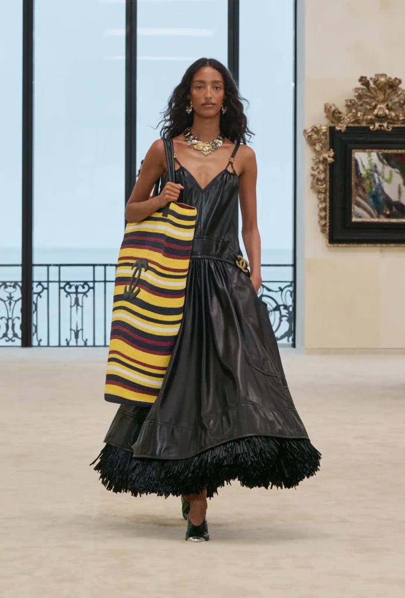 an image describing the Chanel Cruise collection shown in Biarritz by designer Matthieu Blazy. The article details clothing pieces and front row guests.