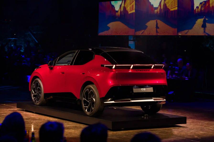Lynk & Co 02 electric vehicle displayed at Spazio Antologico in Milan, showing the car's front three-quarter view against architectural backdrop