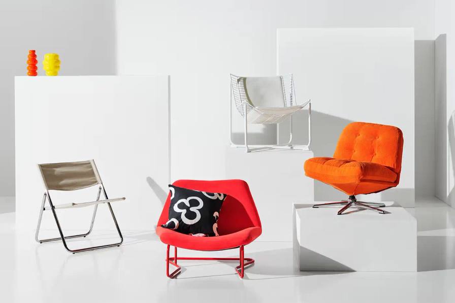 Ikea Visual guide to IKEA's Nytillverkad collection, displaying eight redesigned furniture and textile pieces from the 1960s to 1990s. Each item is labeled with its original name, year of first design, designer's name, and current color variation. The collection includes chairs, shelves, vases, and textiles in a vibrant color palette of orange, red, yellow, and blue.