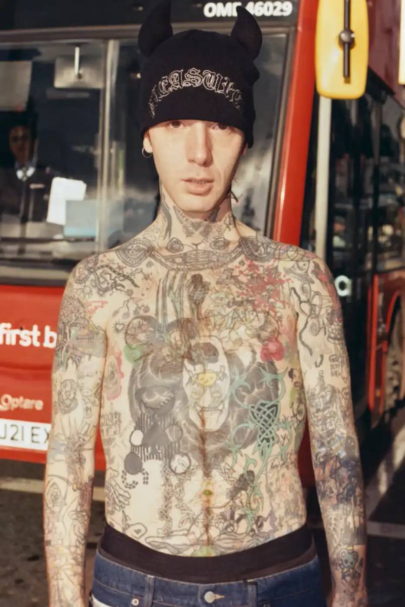 An article detailing the PLEASURES Spring 2026 clothing collection featuring workwear, denim, and graphic shirts shot by Jason Landis in London.