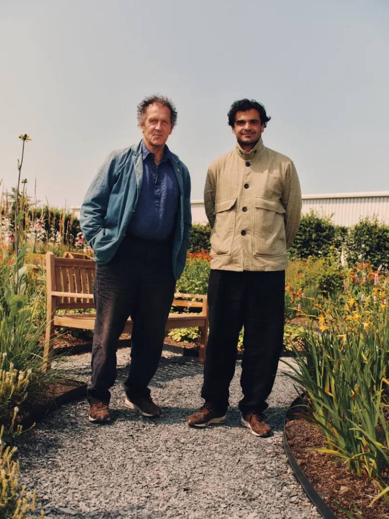 NEW BALANCE OPENS GREEN SPACE AT FLIMBY FACTORY An image showing the new garden built outside the New Balance shoe factory in Flimby, featuring green plants, wooden benches, and custom birdhouses.