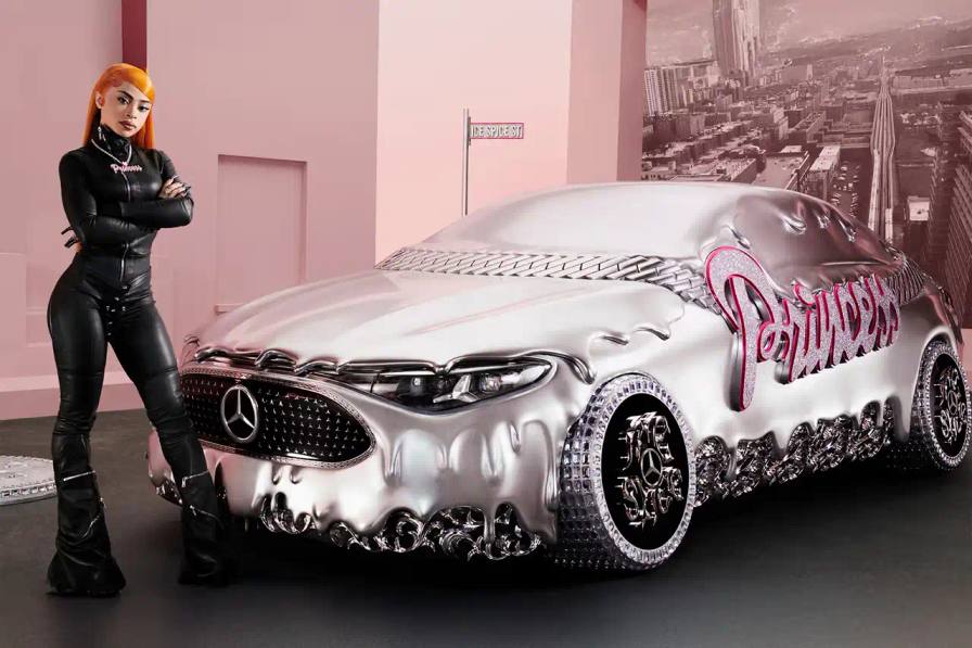 CLA GETS ROYAL CHROME TREATMENT IN ICE SPICE'S MERCEDES COLLAB image of rapper Ice Spice's custom collaboration with Mercedes-Benz, featuring a chrome-finished CLA model with princess-themed detailing. It explains that this is part of Mercedes' "Class of Creators" initiative, where five artists will create custom interpretations of the CLA. The piece details the unveiling event at Mercedes' New York dealership, which included performances from Broadway's "Hell's Kitchen" cast and music by DJ LPX. The article also mentions Ice Spice's upcoming merchandise collection and notes that other collaborators will include Gustaf Westman, KidSuper, League of Legends, and Hot Wheels.