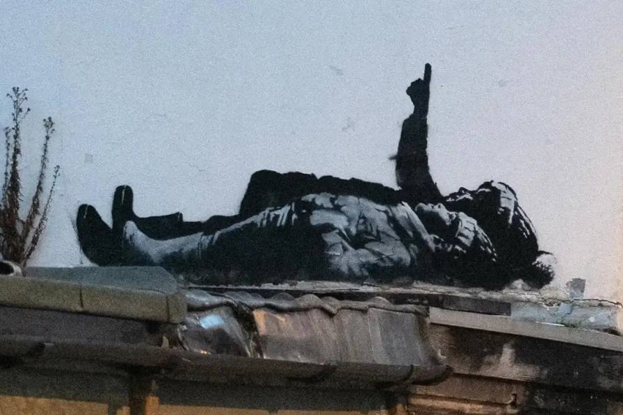 BANKSY UNVEILS TWIN LONDON MURALS Two identical street art pieces by Banksy appeared in London, depicting children in winter clothing lying on the ground and pointing skyward.