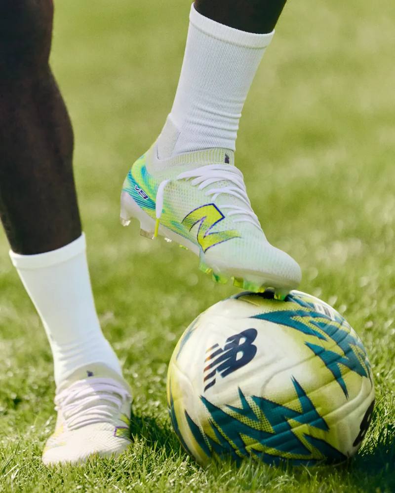 Image of the new alkaline green and metallic blue New Balance Furon v9 football boots showing the soleplate and upper design.
