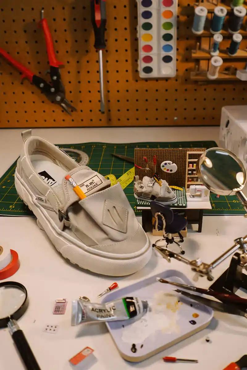 Vans x Nicole McLaughlin Slip-On RS shoes featuring cargo pouches, adjustable straps, and lugged outsoles in natural canvas and charcoal colorways.