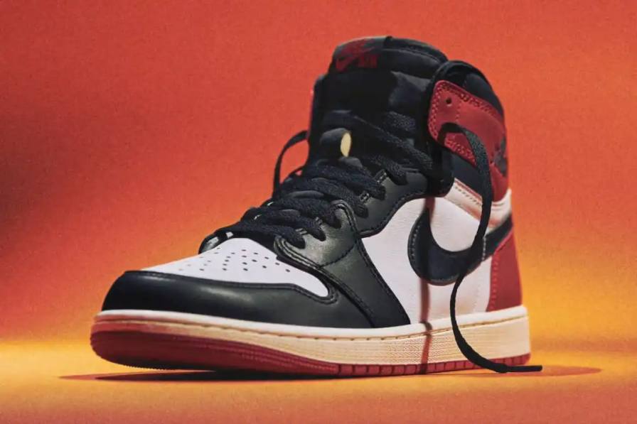 Article about the Air Jordan 1 'Black Toe Reimagined' sneaker launching February 15, 2025. The shoe features white leather with black and red accents, commemorative text from Jordan's rookie season, and releases for $180 during NBA All-Star Weekend."
