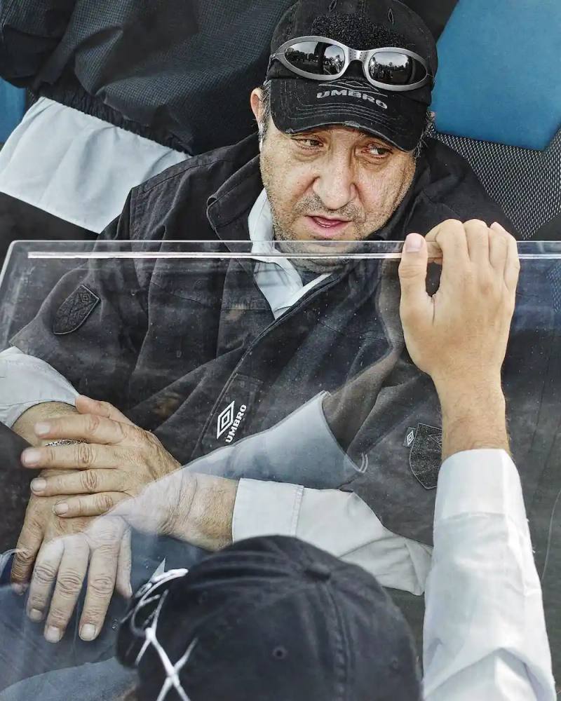 Campaign image for Umbro by Slam Jam Spring/Summer 2025 collection, photographed by Satoshi Fujiwara. Models wearing security-inspired sportswear inside a bus, capturing the atmosphere of football away trips.