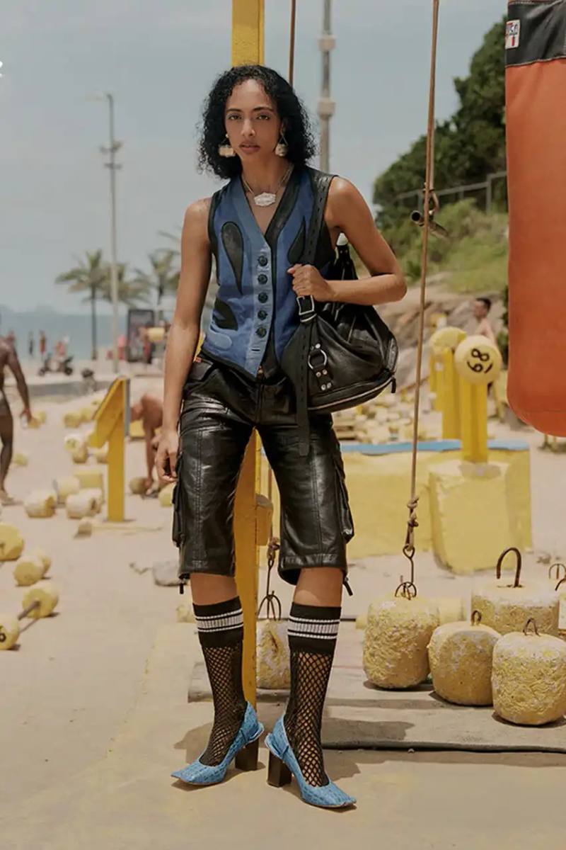 An image description for screen readers that highlights the key visual elements of the Clarks x Martine Rose SS25 campaign, focusing on the three shoe styles (Derby, Torview, and Heel) photographed on local beachgoers, showcasing the unique design details, textures, and color palette of the collection.