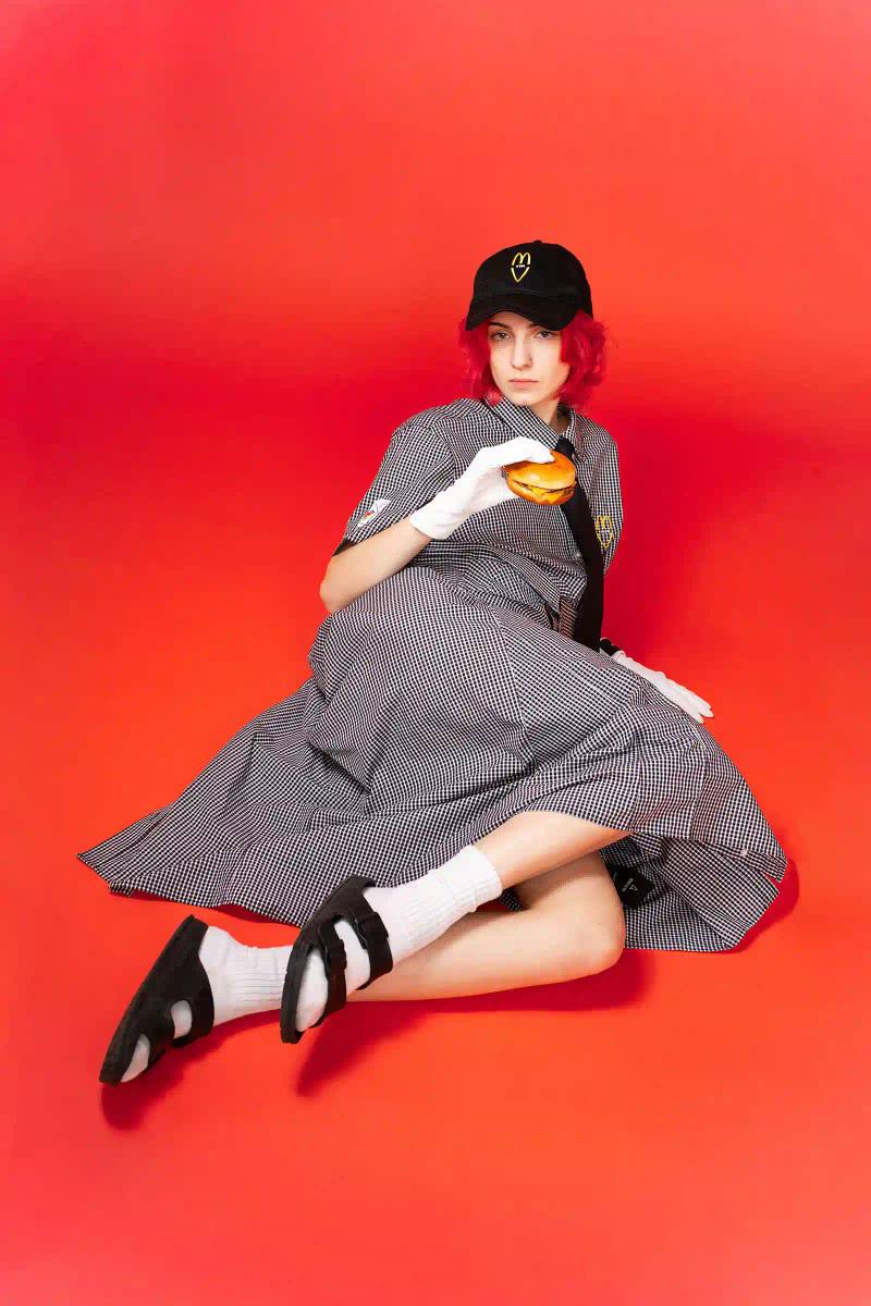 McDonald's/VAIN Models wearing McDonald's-inspired streetwear collection by VAIN, featuring redesigned uniforms in red, yellow, and black colors on a runway.