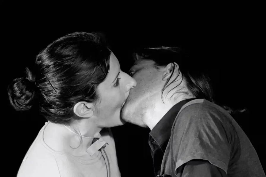 image reports on an upcoming art exhibition at Cukrarna Gallery in Ljubljana, Slovenia, featuring the collaborative work of performance artists Marina Abramović and Ulay. The exhibition, titled "ART VITAL – 12 Years of Ulay / Marina Abramović," opens November 30 and presents documentation of performances, personal correspondence, and archival materials from their 12-year partnership (1976-1988). The article describes their collaborative practice, key performances including "Rest Energy" and "Imponderabilia," and their final joint work "The Great Wall Walk." The exhibition includes previously unseen materials and coincides with a reissue of their 1980 publication "Relation Work and Detour."