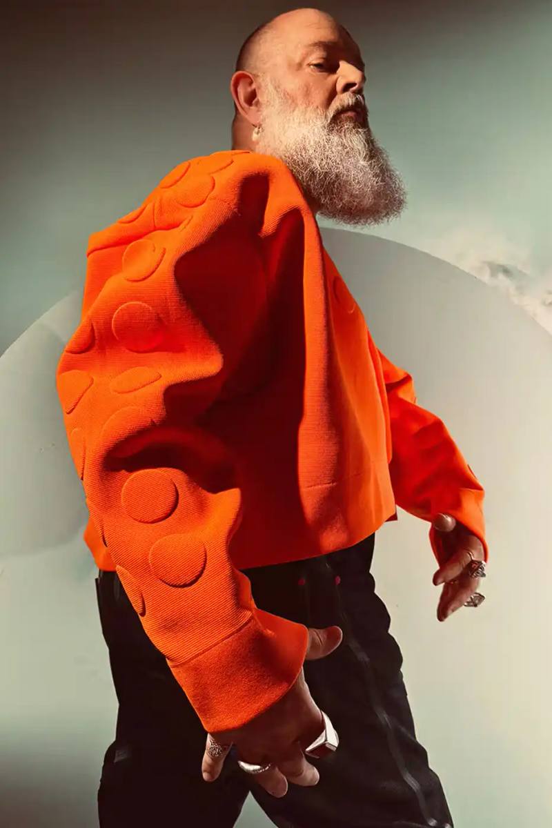 Walter Van Beirendonck/G-Star The Walter Van Beirendonck x G-STAR 'Denim With Balls' collection featuring innovative denim pieces constructed with glue and design tape instead of traditional sewing methods. Items displayed include an oversized jacket, straight-leg jeans, box-cut shorts, and a cap with an upside-down human figure motif.