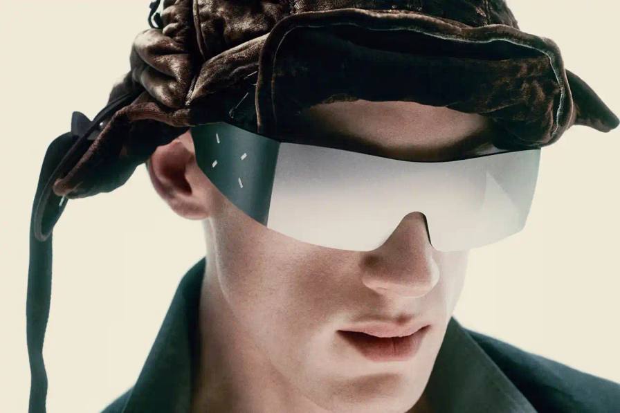 Maison Margiela/Gentle Monster Maison Margiela and Gentle Monster collaborative eyewear collection featuring avant-garde frames with cable temple details and distinctive metallic finishes. The sunglasses showcase the signature Margiela white stitch motif alongside cybercore-inspired design elements.