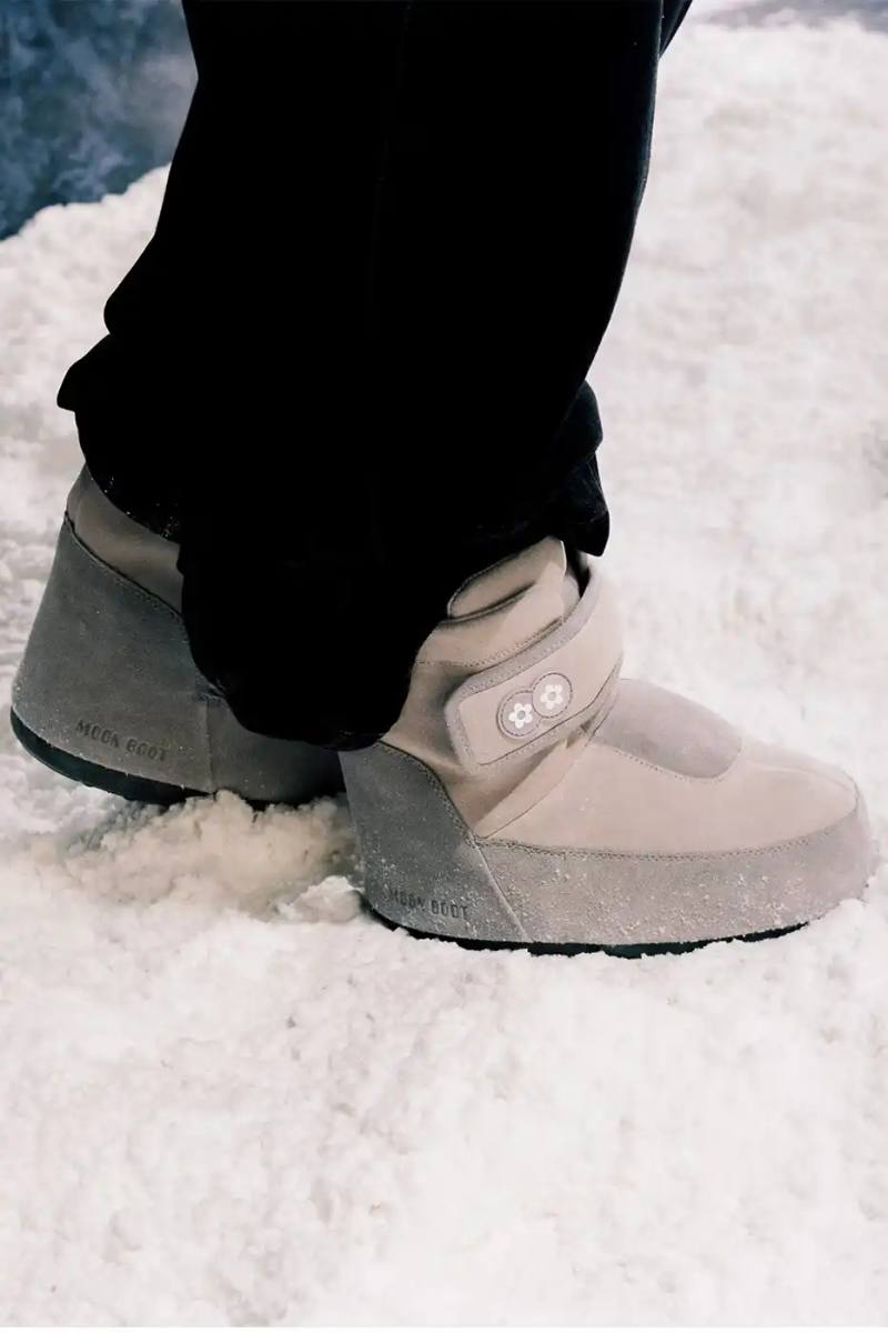 Moon Boot collaborates with VANDYTHEPINK on Icon Strap boot featuring padded strap closure, multicolored suede upper, and flower details in two neutral colorways.
