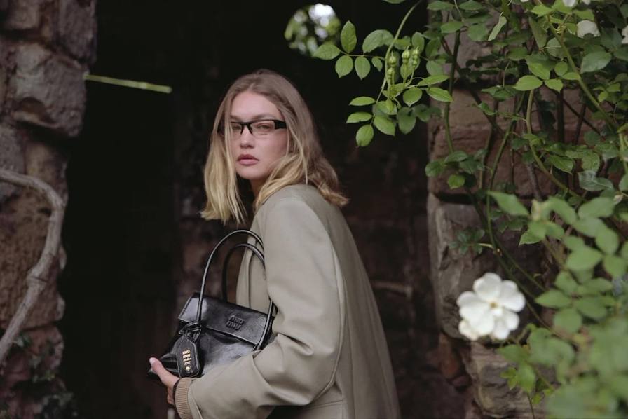 MIU MIU HOLIDAY 2025 CAMPAIGN IS HERE Fashion campaign photographed by Angela Hill shows models in an English countryside manor wearing embroidered duchess satin, patchwork shearling, and stretch leather boots from the fall/winter 2025 collection.