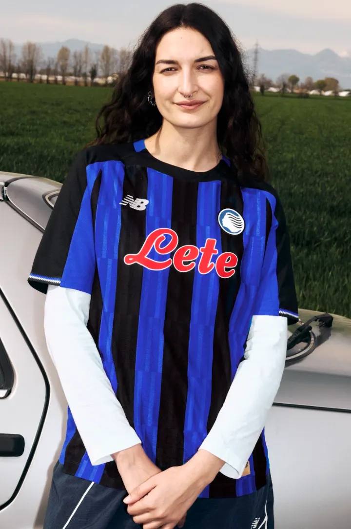 NEW BALANCE REVEALS ATALANTA BC 2026/27 KIT An image of the new Atalanta BC home jersey for the 2026/27 season, featuring Oasis Blue and black vertical stripes with metallic accents.
