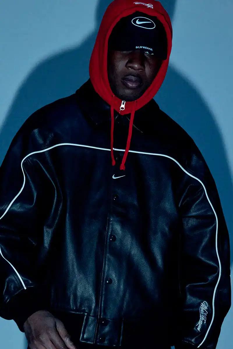 Supreme x Nike Spring 2025 Collection featuring black and white Leather Varsity Jackets, purple, yellow and black Track Suits, striped Rugby shirts, Sweater Vests, Hooded Sweatshirts, and accessories including Running Hats and Leather Shoulder Bags.