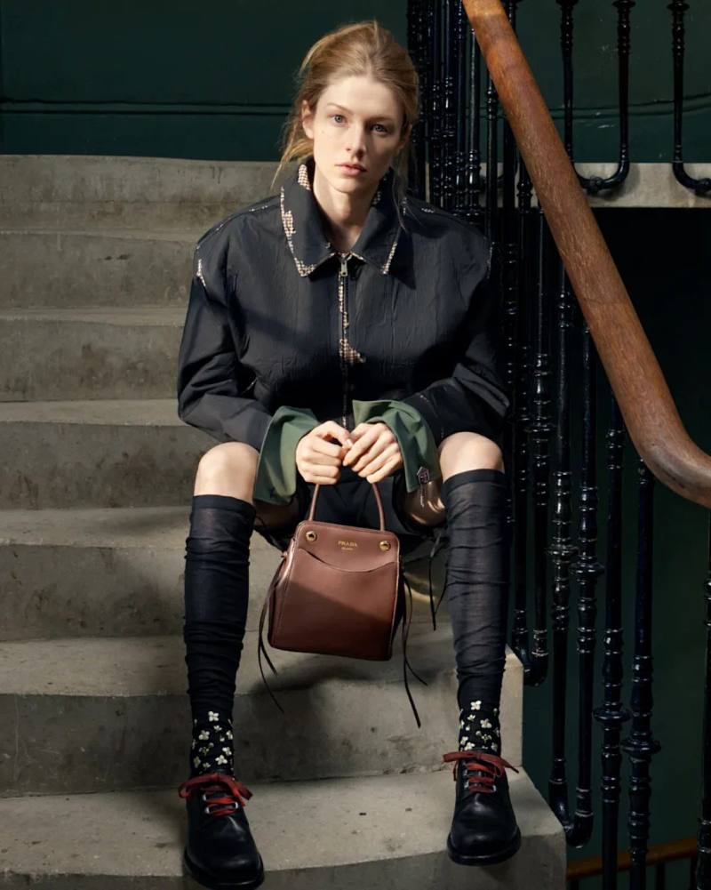 image of the Prada Carry bag from the Fall Winter 2026 collection. The accessory features soft calfskin leather and front pockets.