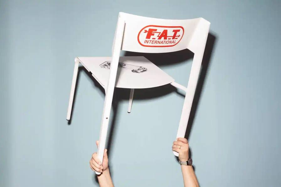 Limited-edition aluminum chair with racing-inspired design, featuring sleek metal frame and Porsche 959 graphic detail. Created by Marco Dessi for FAT International.