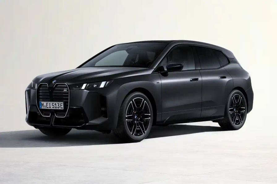 BMW iX M70 xDrive electric SUV in front three-quarter view, showing darkened kidney grille with M badge and black exterior mirrors