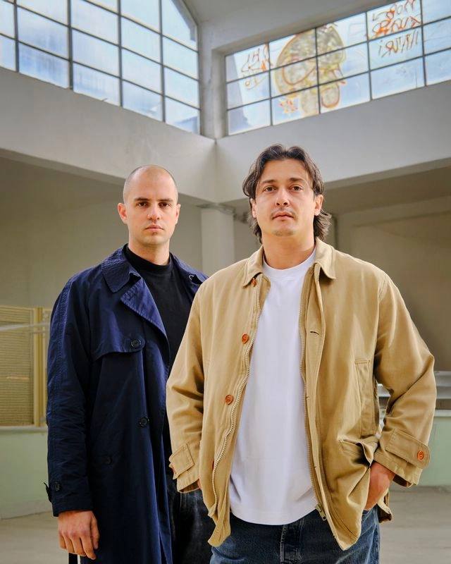 Edoardo Pandolfo + Francesco Palù Portrait ©Tommaso Mariniello image detailing the 6:AM glass exhibition and Bar Pieno schedule at Milan Design Week 2026.