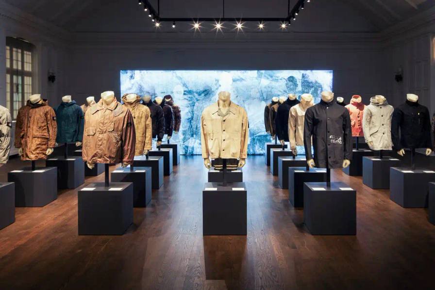 Stone Island garments on display at Holt Renfrew, showcasing various innovative fabrics and designs from 1984 to 2024