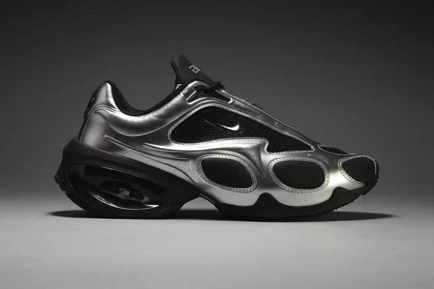 Nike Air Max Muse sneaker with metallic silver finish, featuring an architectural raised arch, semi-lustrous Air unit, and contemporary textured upper design, showcasing exaggerated proportions and technical details.