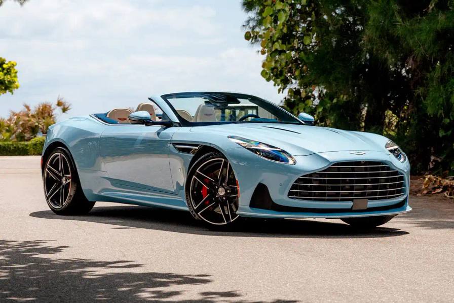 image of Aston Martin's custom DB12 Volante convertible designed for the Florida market, featuring specialized blue paint with glass particles, white accent striping, and interior elements inspired by Palm Beach including palm leaf motifs and regional coordinates.