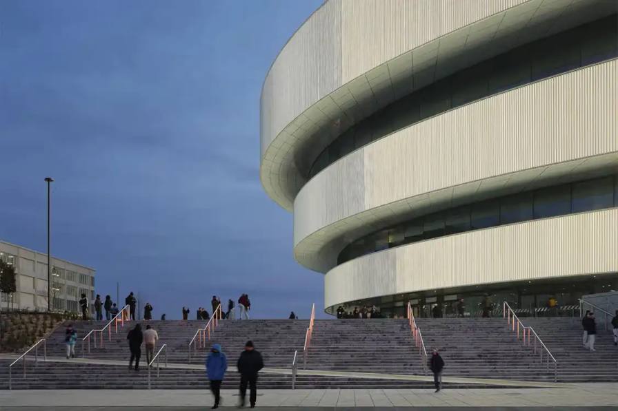 The Milano Santa Giulia Arena, a 16,000-capacity venue designed by David Chipperfield Architects with Arup, features an elevated public plaza, three floating metallic rings, and sustainable energy systems for the 2026 Winter Olympics.