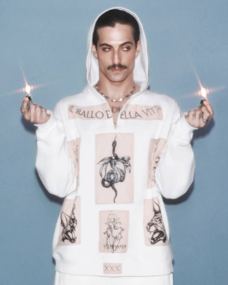 The article discusses a new capsule collection collaboration between the fashion brand Diesel and Damiano David, the lead singer of the band Måneskin. The collection combines Diesel's edgy, gender-fluid aesthetic with elements inspired by Damiano's personal style and tattoos. Key pieces include oversized tops, drawstring pants, and denim items with distinctive treatments. The capsule is now available for purchase on Diesel's website.