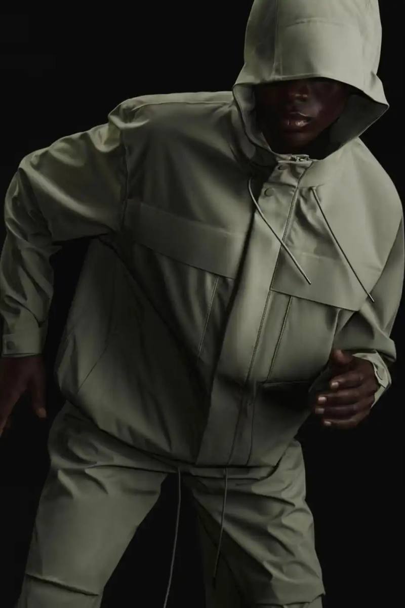 RAINS Spring/Summer 2025 collection featuring models wearing the new Suva Hardshell jackets and pants in an urban setting, showcasing the matte finish and minimalist design of the waterproof apparel.