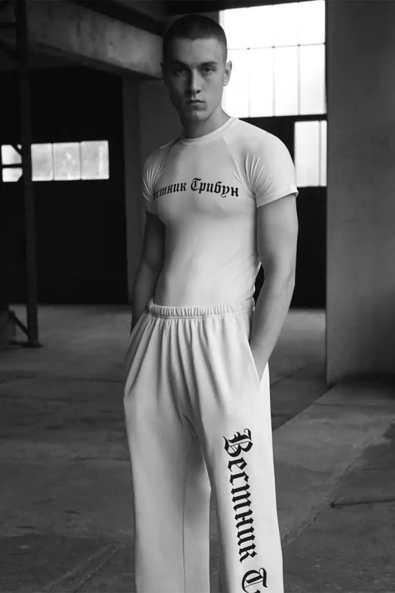 Article about YZY's new collection designed by Gosha Rubchinskiy, highlighting a nine-piece monochromatic line with Cyrillic text elements inspired by The New York Herald Tribune and Jean-Luc Godard's Breathless film.