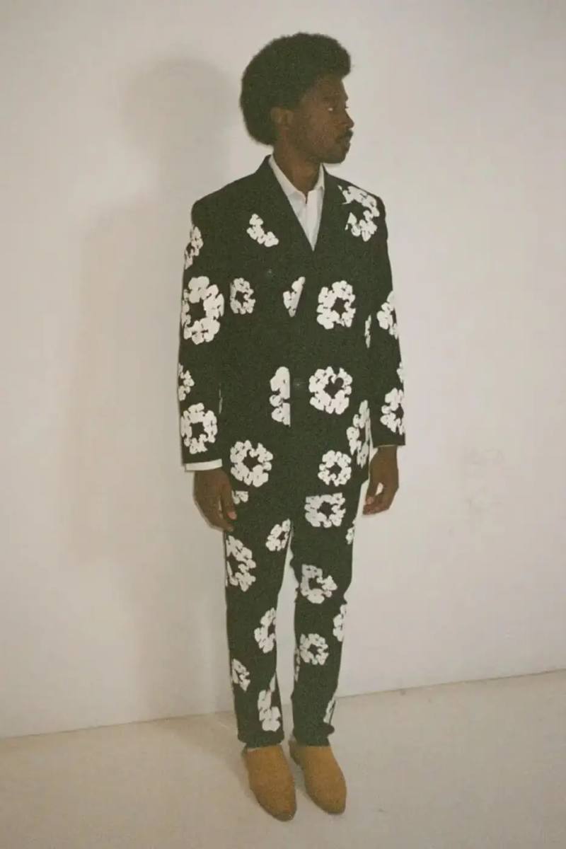 SAINT Mxxxxxx SAINT Mxxxxxx and Denim Tears collaborative Fall/Winter 2024 collection, displaying a tailored double-breasted blazer with wreath print, matching slacks, and a necktie