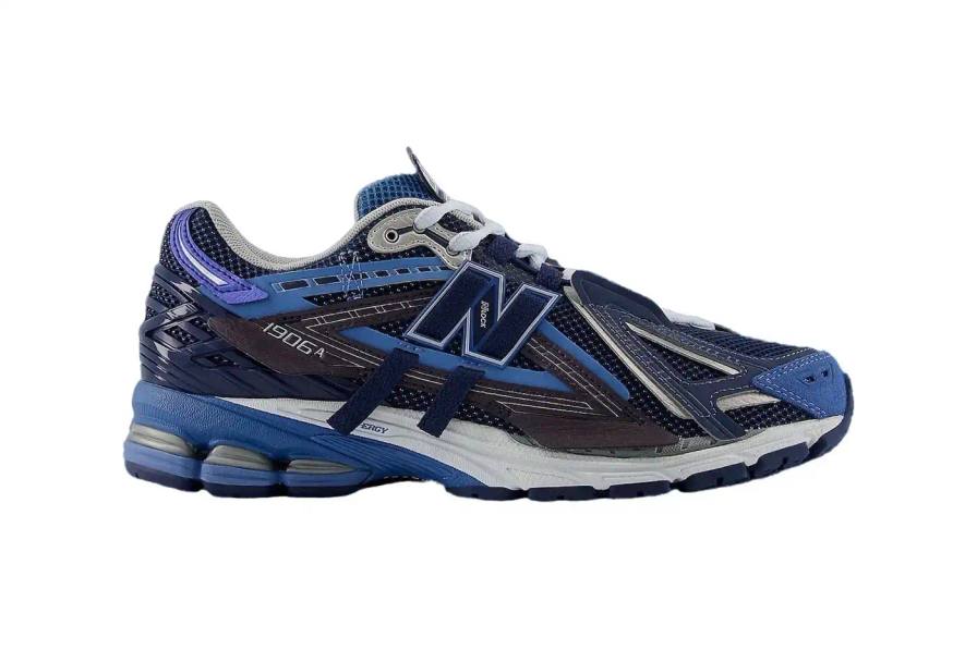 New Balance New Balance 1906A sneaker in Navy and Vintage Indigo colorway. The shoe features a mesh and synthetic upper with blue suede toe cap, ultramarine stripes on the sides, and a Sea Stone-colored midsole. Multiple shades of blue create a layered, technical appearance typical of Y2K-era running shoes.