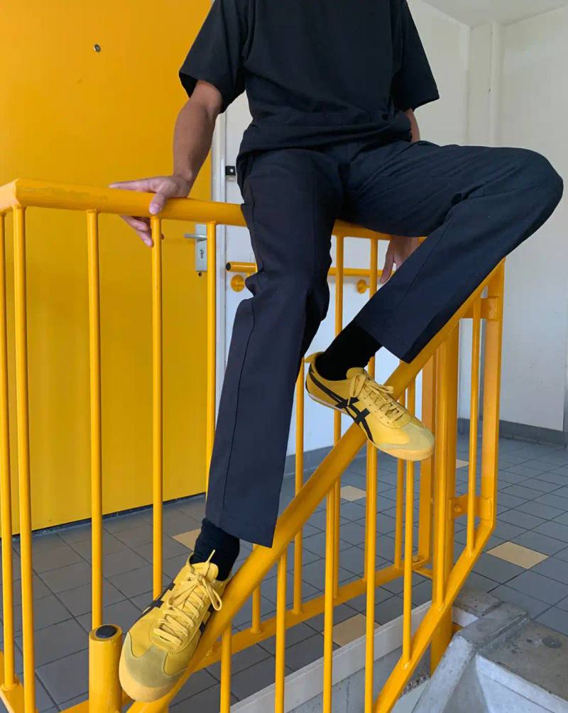 HOW SHAI DATAUKER REDEFINES CLOTHING, IDENTITY, AND DAILY LIFE Shai Datauker wearing his daily uniform-a bright red Adidas tracksuit and white t-shirt-sitting in a minimalist interior during an interview about fashion and identity.
