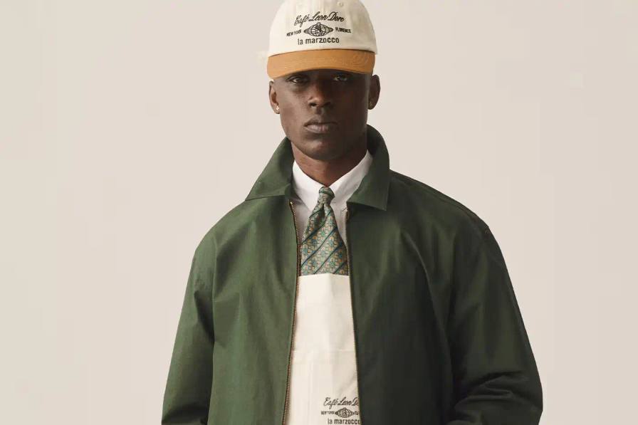CAFÉ LEON DORE PARTNERS WITH LA MARZOCCO ON EXCLUSIVE COFFEE COLLECTION Image of the collaboration between Café Leon Dore (part of Aimé Leon Dore) and La Marzocco. The partnership features a custom-designed Linea Micra espresso machine in green with brass and walnut details, plus co-branded apparel including aprons, t-shirts, and hats. The collection is available exclusively through Aimé Leon Dore's stores and website. The article provides details about the machine's professional capabilities despite its compact size, and notes that it's being produced in limited quantities.