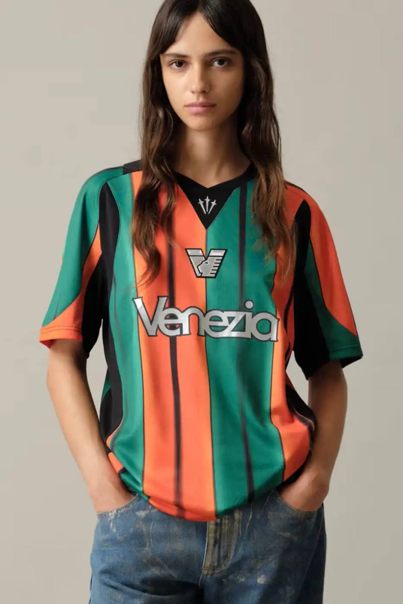 VENEZIA FC NOCTA THIRD JERSEY 2025/26 SEASON LAUNCH image of Venezia FC Third Jersey 2025/26 featuring orange black green vertical stripes with silver NOCTA branding