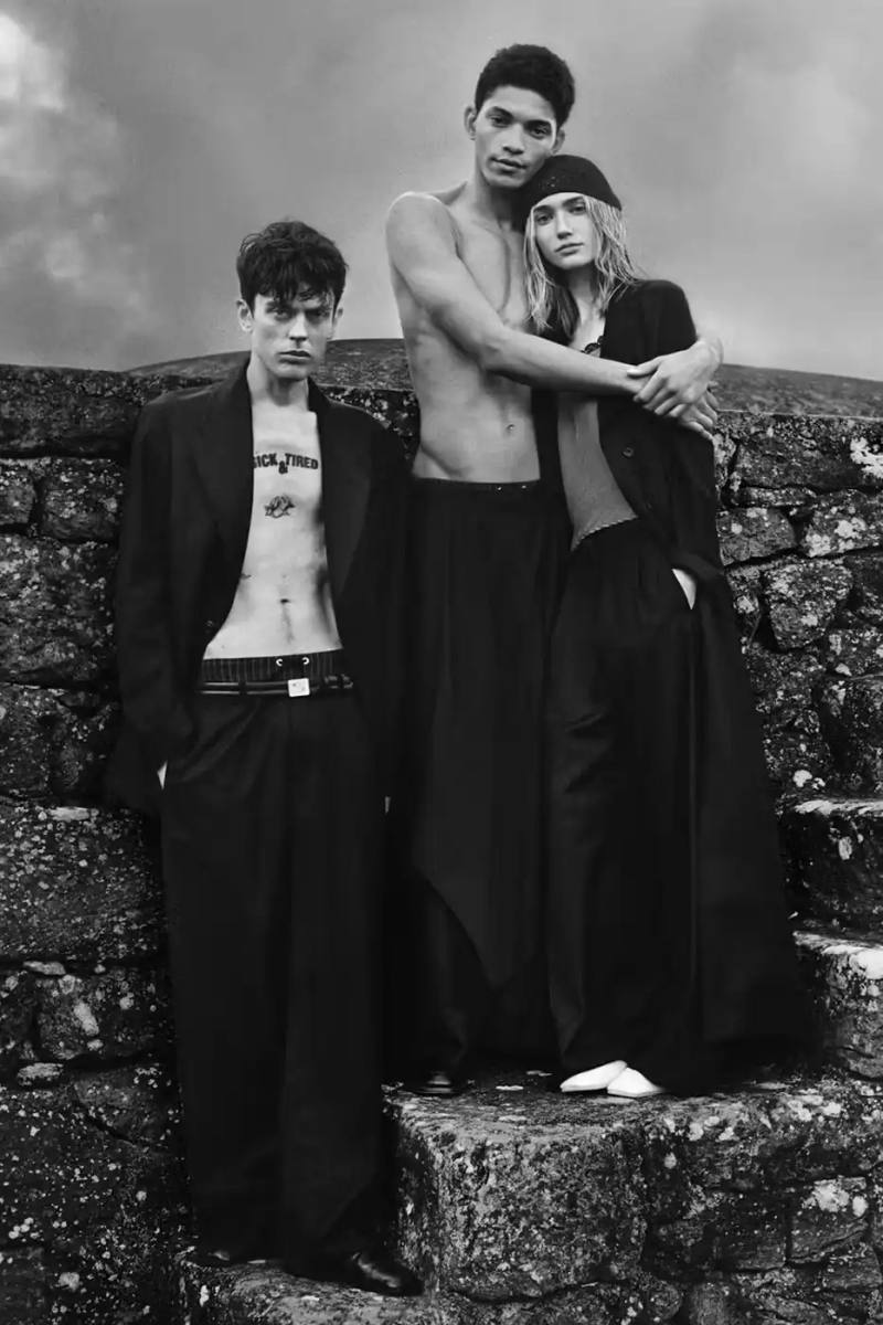 image of second collaboration between Emporio Armani and Our Legacy Work Shop, detailing the expanded capsule collection that includes both menswear and womenswear. The collection features designs reimagined from Armani archives with East Asian influences, using both classic and recreated vintage fabrics. The article describes the campaign photographed by Alasdair McLellan on Pantelleria island, and provides information about the May 16 launch date and various retail locations where the collection will be available.