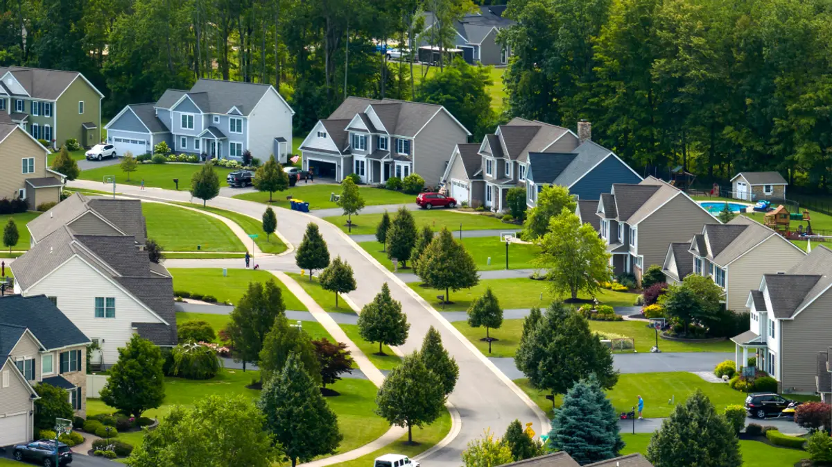 An aerial view of a suburban neighborhood with large homes, spacious lots, and tree-lined streets.