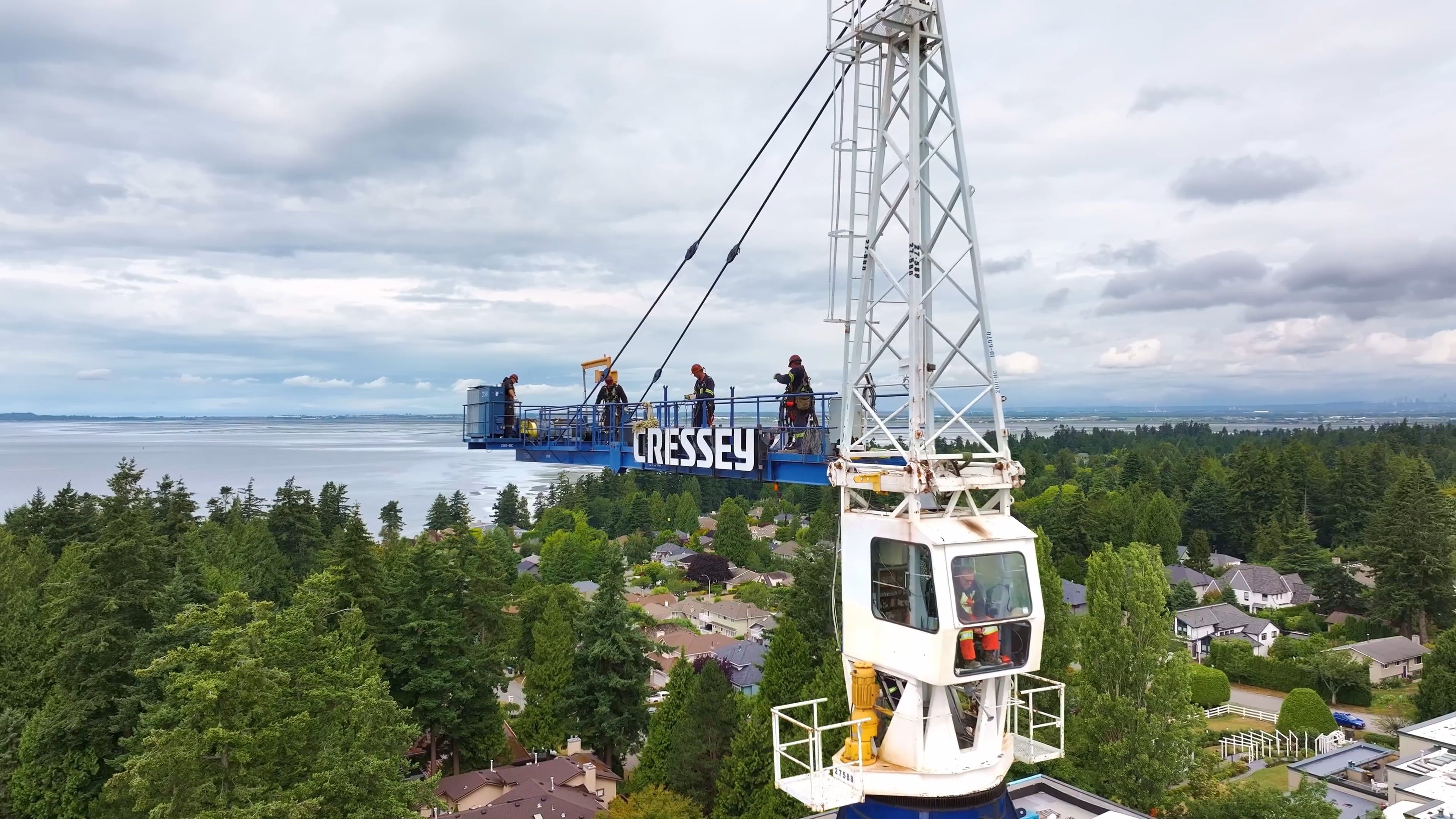 Workers disassembling a construction crane on a cloudy day