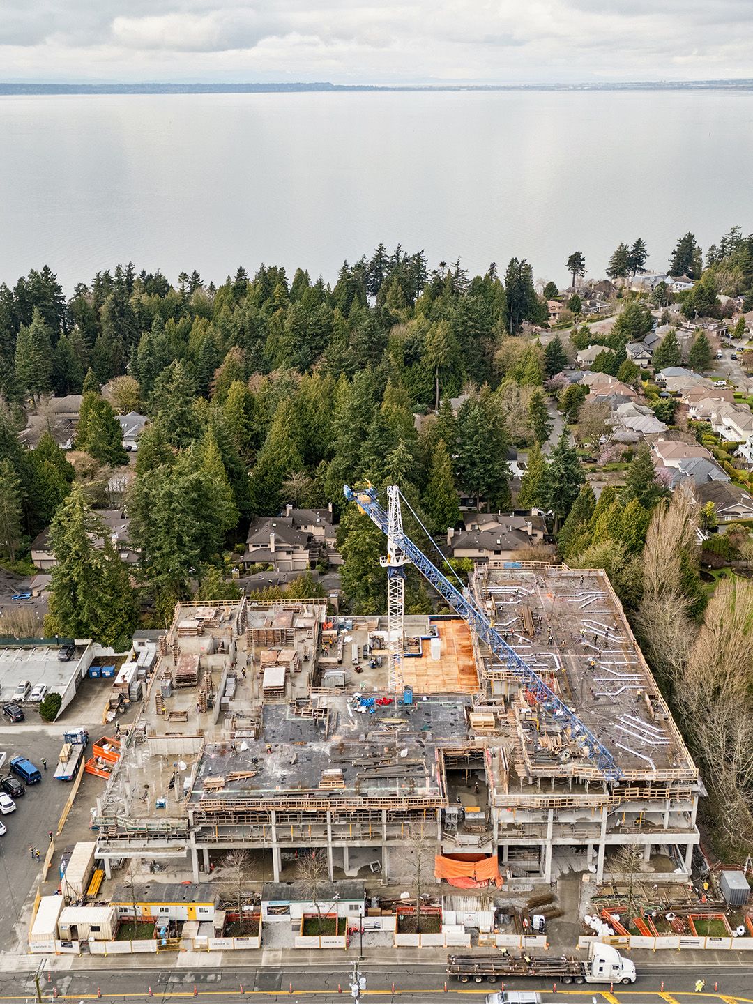 Concrete residential building under construction in peaceful neighbourhood with trees and ocean views