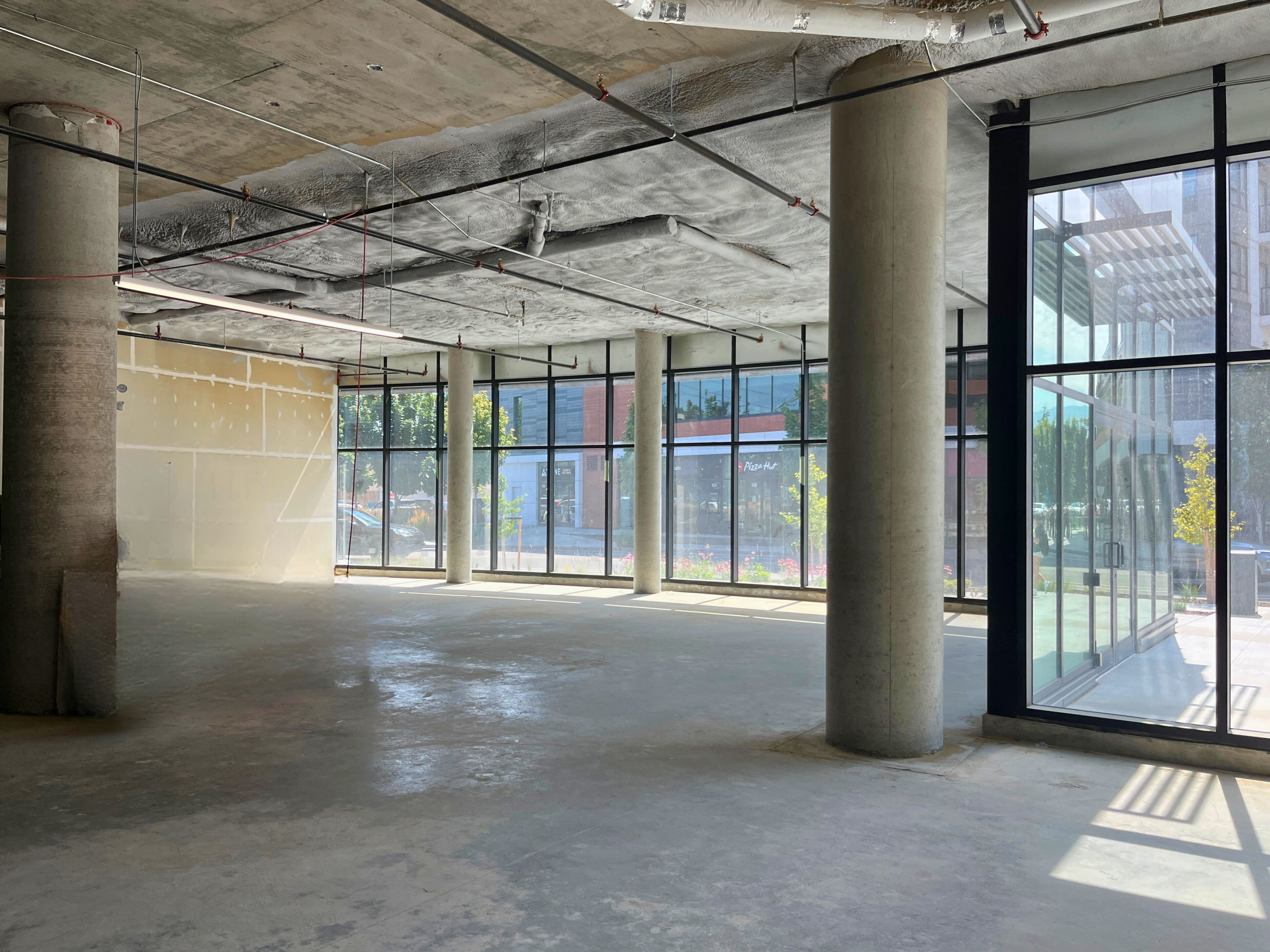 Spacious interior photo of a new, vacant commercial space with sunshine outside