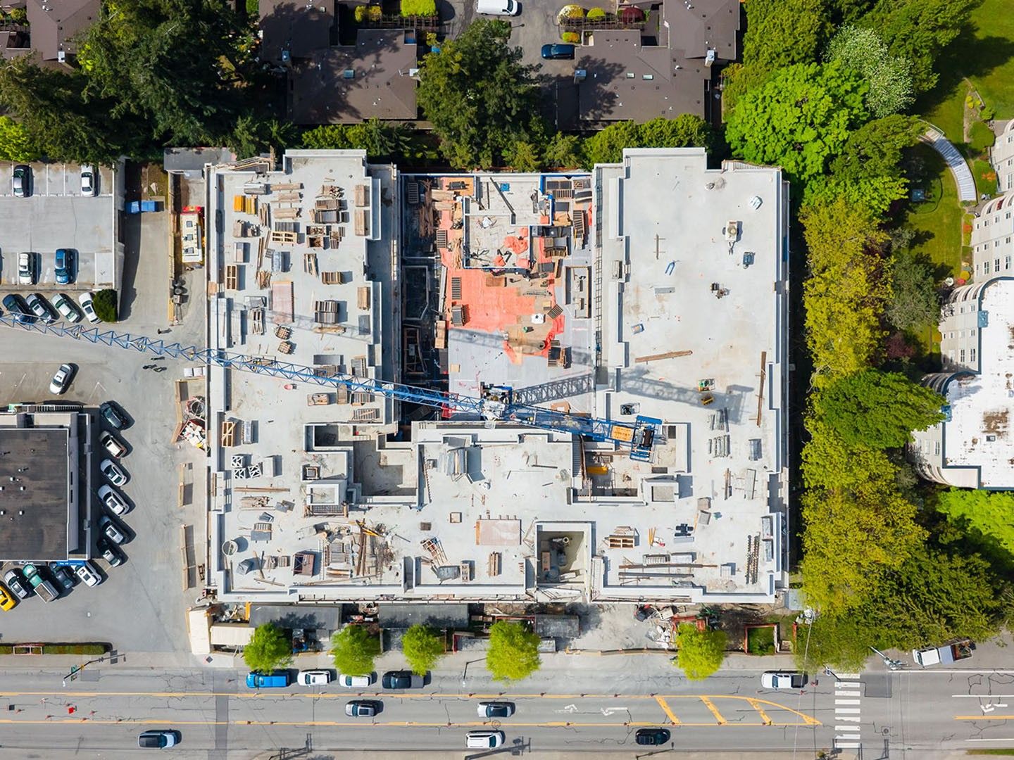 Concrete residential building under construction in peaceful neighbourhood with trees and ocean views
